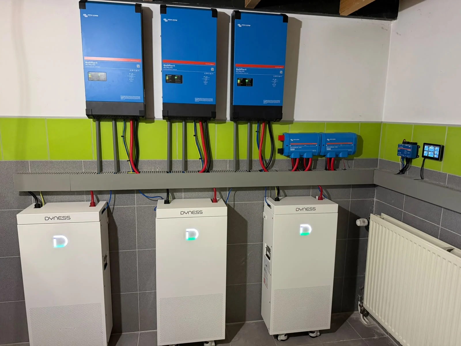 Drie Victron-omvormers met vier batterijkasten eronder